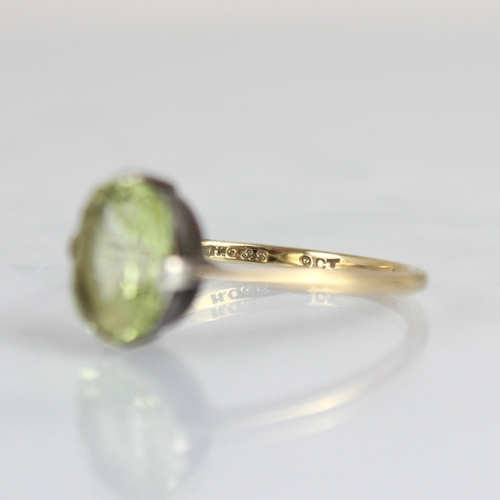 227 - An Edwardian style yellow metal dress ring, the central cushion cut untested chrysoberyl within claw... 