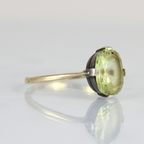 227 - An Edwardian style yellow metal dress ring, the central cushion cut untested chrysoberyl within claw... 