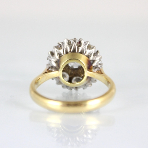 232 - An Edwardian style diamond cluster ring, the raised central round cut diamond within surround of eig... 