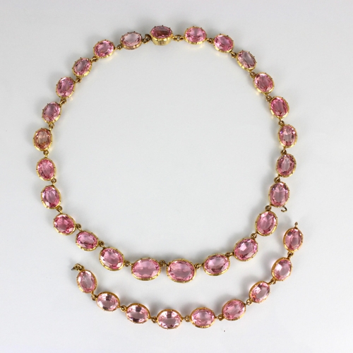 236 - An early/mid 19th century gilt metal paste necklace, the twenty graduated oval cut pink stones withi... 