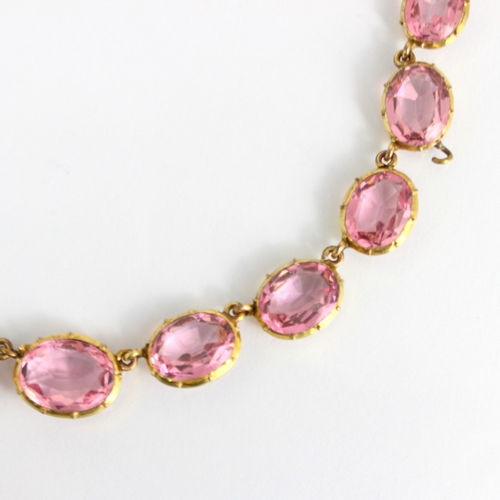 236 - An early/mid 19th century gilt metal paste necklace, the twenty graduated oval cut pink stones withi... 