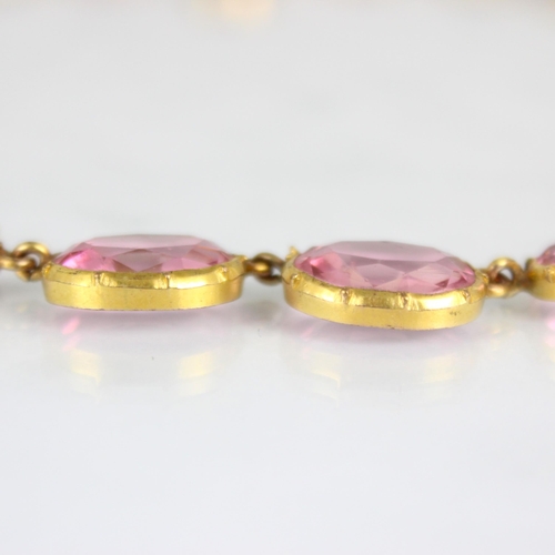 236 - An early/mid 19th century gilt metal paste necklace, the twenty graduated oval cut pink stones withi... 