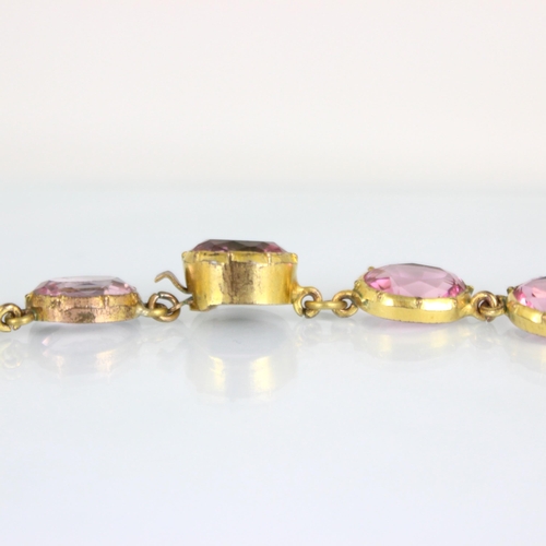 236 - An early/mid 19th century gilt metal paste necklace, the twenty graduated oval cut pink stones withi... 