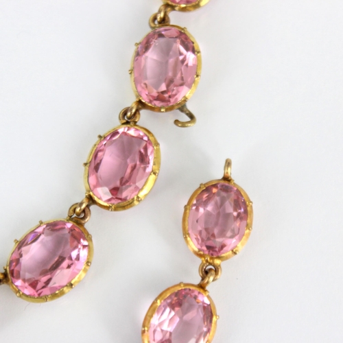 236 - An early/mid 19th century gilt metal paste necklace, the twenty graduated oval cut pink stones withi... 