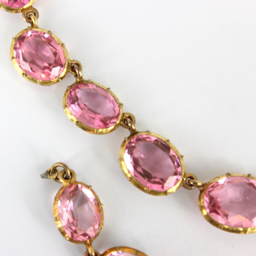 236 - An early/mid 19th century gilt metal paste necklace, the twenty graduated oval cut pink stones withi... 