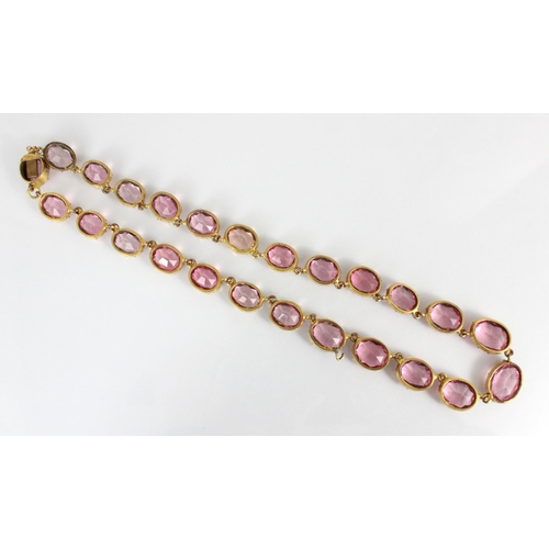 236 - An early/mid 19th century gilt metal paste necklace, the twenty graduated oval cut pink stones withi... 