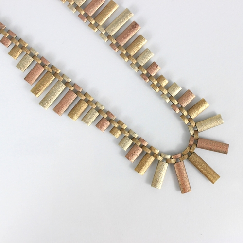 244 - A 9ct three tone fringe necklace, the graduated hollow rectangular panels with textured detail, lead... 