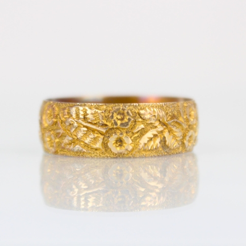 252 - A 19th century 18ct yellow gold ring, continuously engraved with floral design, indistinctly stamped... 