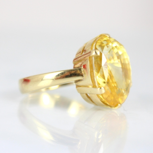 257 - A bespoke untested yellow sapphire cocktail ring, possibly Sri Lankan, the fancy oval cut stone with... 