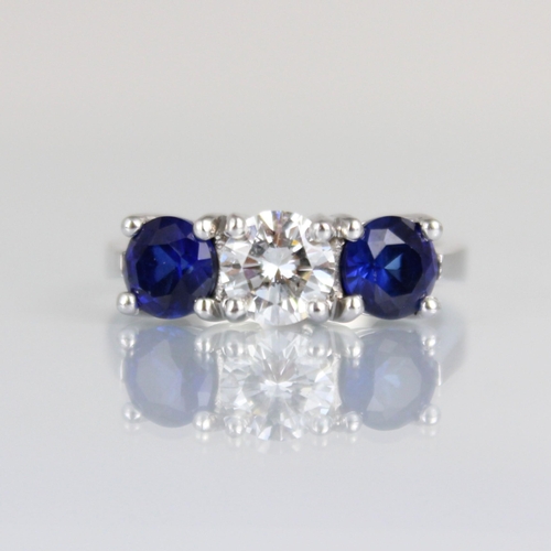 263 - A bespoke sapphire and diamond three stone ring, the central round cut diamond with smaller round cu... 