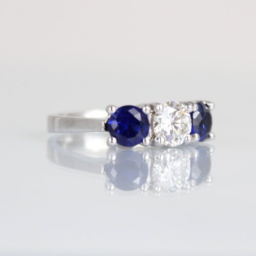 263 - A bespoke sapphire and diamond three stone ring, the central round cut diamond with smaller round cu... 