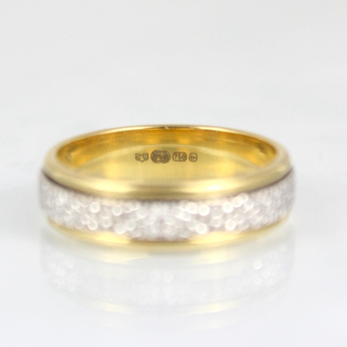 264 - A two tone yellow metal spinning ring, the central strip of white metal with engraved detail, within... 