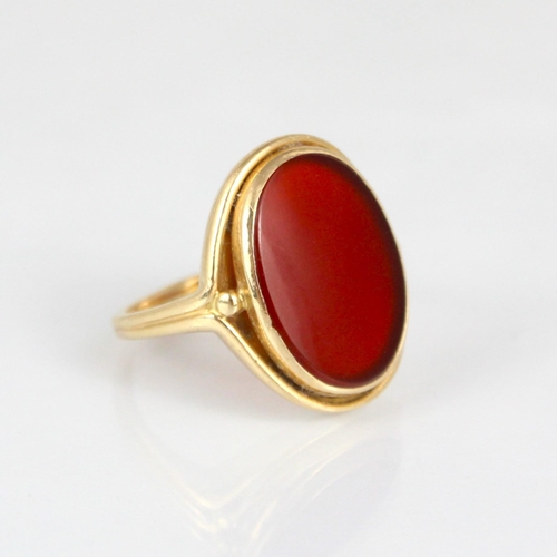 270 - A 19th century style carnelian set ring, the oval cut carnelian within rub over and openwork mount, ... 