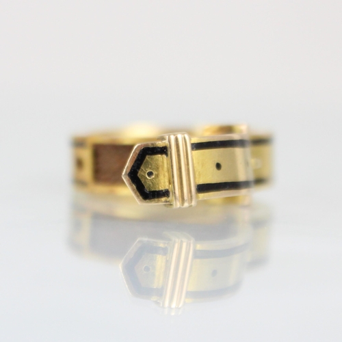 274 - A 19th century enamel mourning ring, formed as buckle with black enamel border, hinged to reveal pla... 