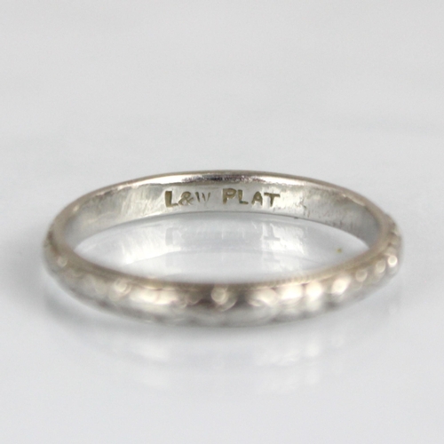 284 - An early 20th century white metal wedding band, engraved with continuous floral design, ring size L,... 