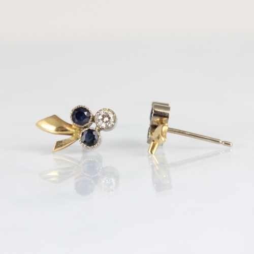 286 - A pair of diamond and untested sapphire stud earrings, of trefoil stylised floral design, within mil... 