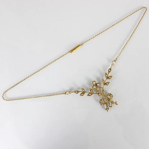 294 - An early 20th century yellow metal and seed pearl necklace, the foliate designed front with trefoil ... 