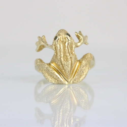 302 - A yellow metal novelty ring, the head designed as a frog with realistically chased detail and green ... 