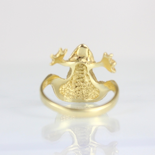 302 - A yellow metal novelty ring, the head designed as a frog with realistically chased detail and green ... 