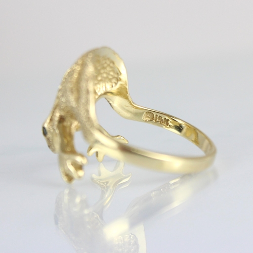 302 - A yellow metal novelty ring, the head designed as a frog with realistically chased detail and green ... 