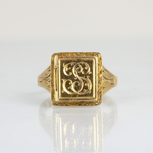 303 - A 19th century style hidden locket ring, the raised square head opening to reveal locket, engraved m... 