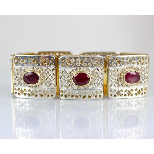 315 - A contemporary two tone panel bracelet, the seven square openwork panels set in white metal with dia... 