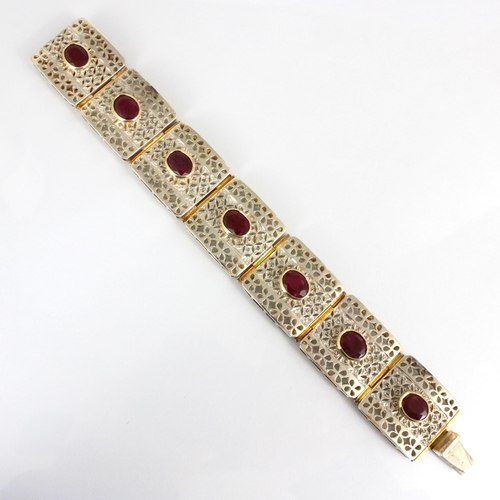 315 - A contemporary two tone panel bracelet, the seven square openwork panels set in white metal with dia... 