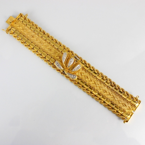 319 - A Tressa yellow metal and diamond bracelet/watch, the circular dial with baton markers, hinged styli... 