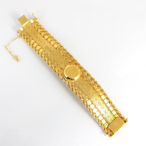 319 - A Tressa yellow metal and diamond bracelet/watch, the circular dial with baton markers, hinged styli... 