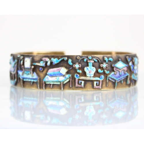 320 - A Chinese enamel and gilt metal bangle, the wide cuff style bangle decorated in naively enamelled sy... 