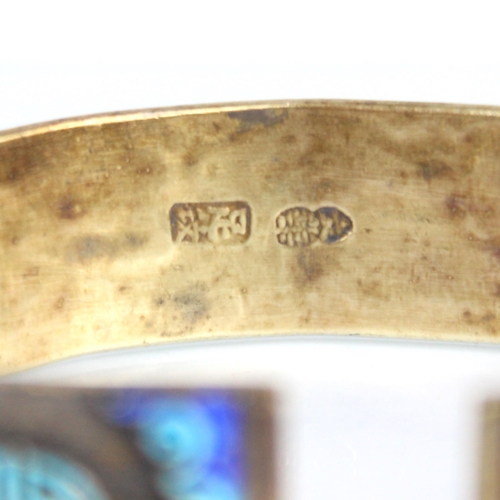 320 - A Chinese enamel and gilt metal bangle, the wide cuff style bangle decorated in naively enamelled sy... 