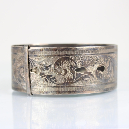 321 - A mid 20th century silver Charles Horner bangle, of cuff design with continuous floral decoration, w... 