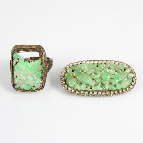 322 - An early 20th century jade and paste seed pearl brooch, the oval carved jade panel depicting birds a... 