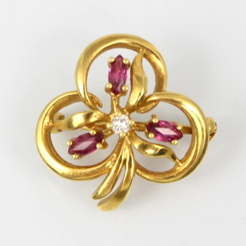 327 - An 18ct yellow gold ruby and diamond brooch, the trefoil stylised floral designed brooch with three ... 