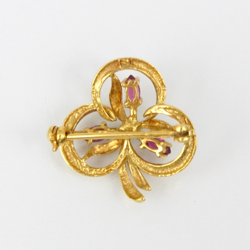 327 - An 18ct yellow gold ruby and diamond brooch, the trefoil stylised floral designed brooch with three ... 