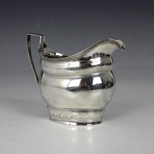 33 - A George III silver milk jug, indistinct makers mark, London 1802, the reeded rim above bulbous body... 