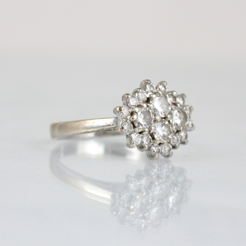 338 - An 18ct white gold diamond cluster ring, the central quatrefoil round cut diamonds within surround o... 