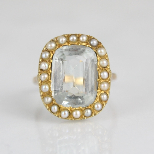 345 - An aquamarine and seed pearl ring, circa 1900, the cushion cut aquamarine within a surround of seed ... 