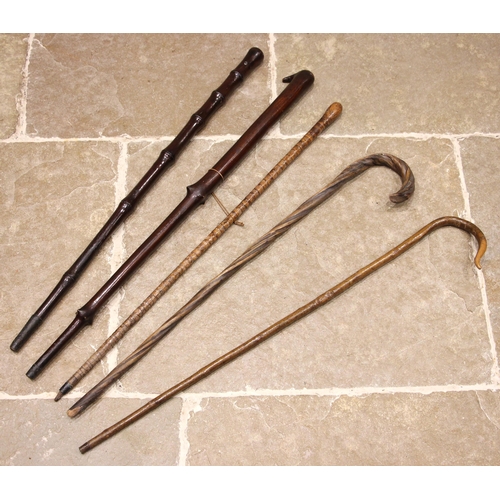 634 - Five assorted walking canes, to include a bamboo effect hardwood example with metal tip inset with C... 