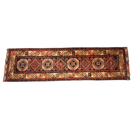 686 - A Caucasian wool runner, in red, blue and ivory colourways, the central field with eight alternating... 