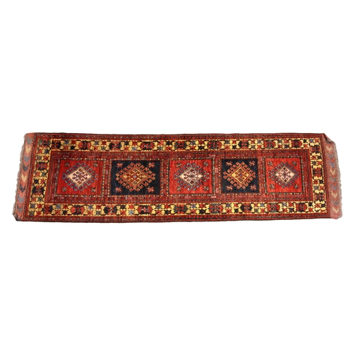 688 - A Pakistan wool runner, in vibrant red, blue and yellow colourways, the central field with five alte... 