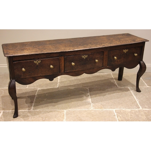 713 - An early 18th century oak Shropshire dresser base, the moulded twin plank top over three pine lined ... 