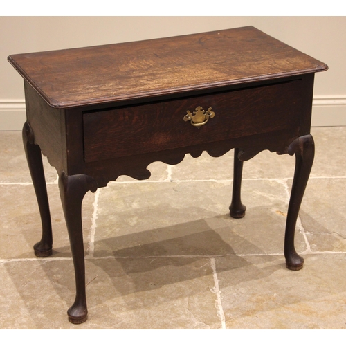 714 - An early 18th century oak side table, the moulded oversailing top with rounded front corners, over a... 