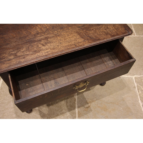 714 - An early 18th century oak side table, the moulded oversailing top with rounded front corners, over a... 