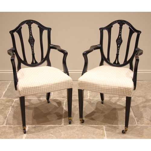 742 - A pair of ebonised Hepplewhite style carver/elbow chairs, 19th century, each with a shield shaped ba... 