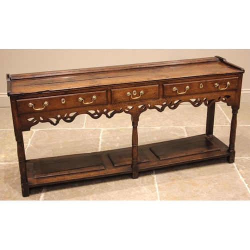 744 - A George III oak Welsh dresser, the moulded cornice and plain frieze applied with iron cup hooks ove... 