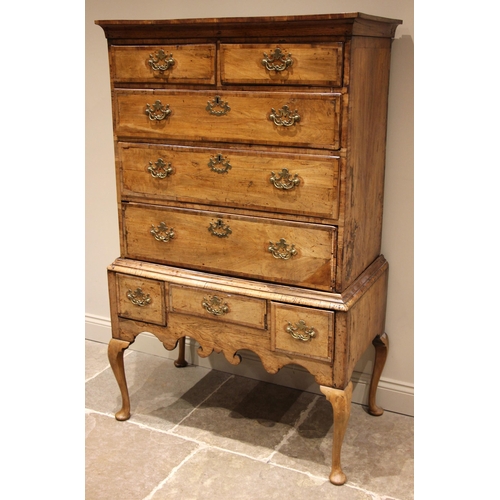 752 - A George I walnut chest on stand, the moulded cornice over an arrangement of two short and three gra... 