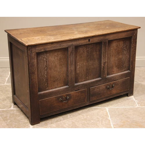 758 - A mid 18th century oak mule chest, the hinged plank top over a three panel front and two lip moulded... 