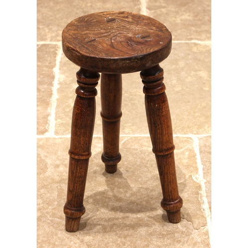 783 - A rustic elm slab top stool, 19th century, the circular figured seat upon three ring turned baluster... 