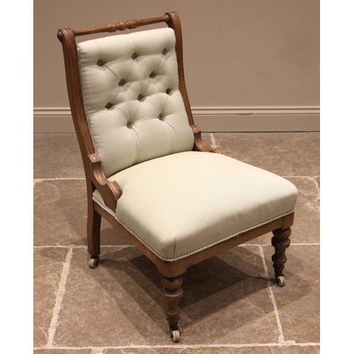 788 - A Victorian honey oak framed low seat chair, with a turned top rail over a button back, sprung strai... 